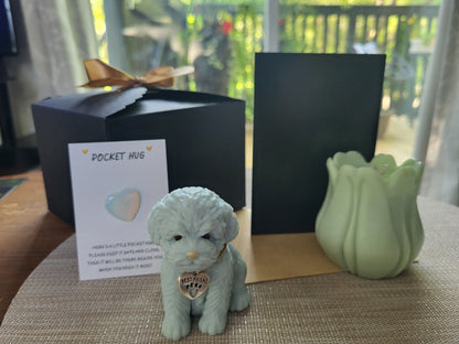 Small dog figurine with a heart-shaped tag, card, and green vase on a textured surface.