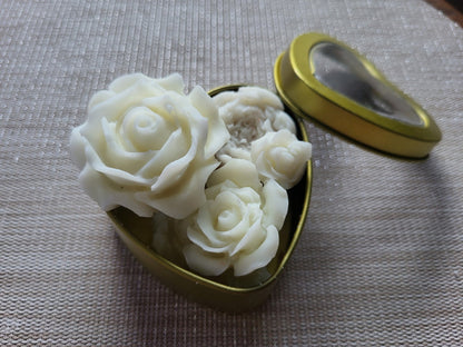 White rose-shaped objects in a gold container on a textured surface